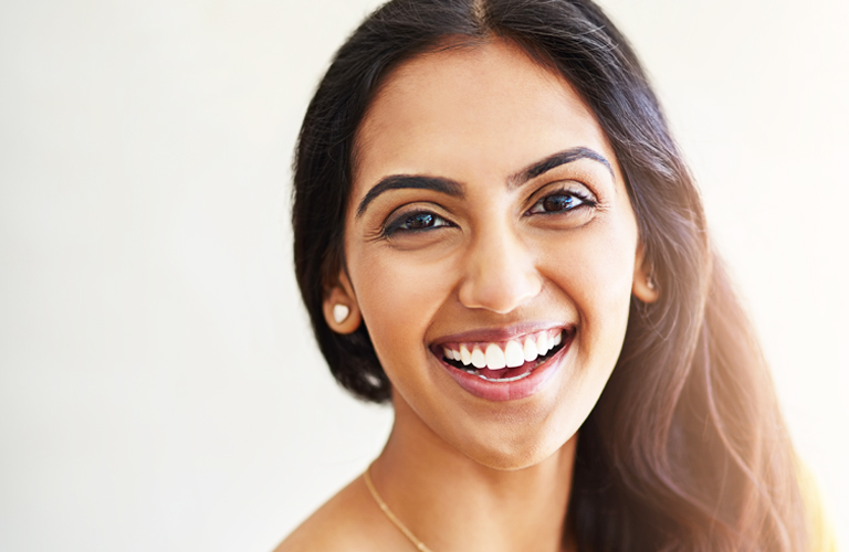 A women looking directly at the camera and smiling after having a smile makeover treatment at Ropergate Dental