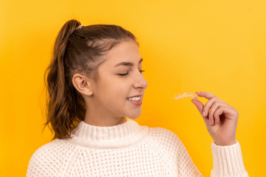 Girl looking at Invisalign aligners in Pontecraft