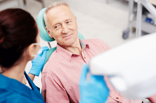 An older man sat in the dentist chair in Pontefract with dental implants