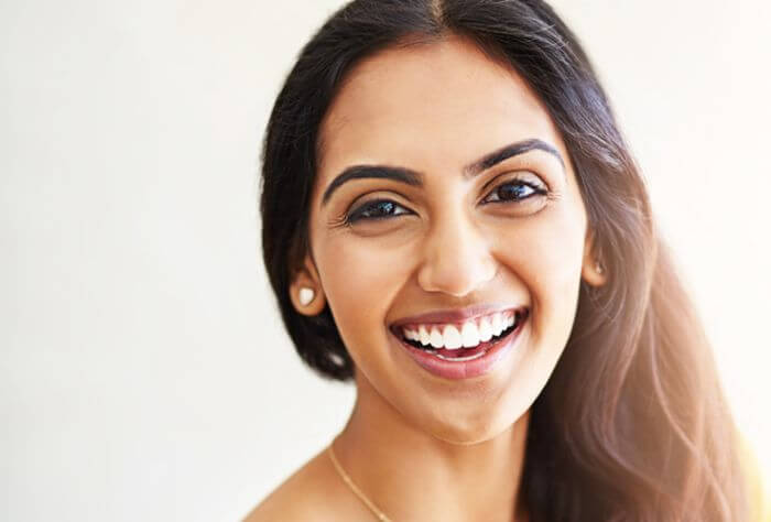 A women looking directly at the camera and smiling after having a smile makeover treatment at Ropergate Dental