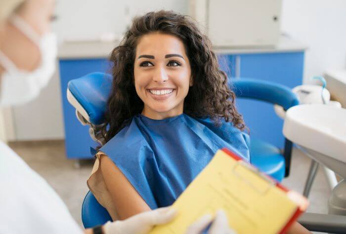Woman smiling at her dentist appointment after originally being nervous